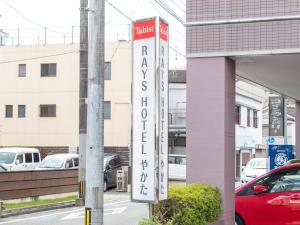 een bord voor een hotel aan de zijkant van een gebouw bij Tabist Rays Hotel Yakata in Miyazaki