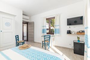 a bedroom with a bed and a table and chairs at Sa Domm'e Galleria in Baunei