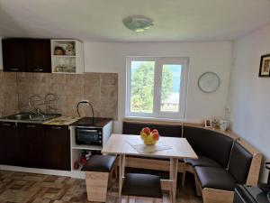 a living room with a table and a kitchen at Casuta Rodi in Gura Negri