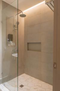 a shower with a glass door in a bathroom at Primeway Suites Cebu in Cebu City