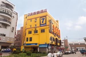un edificio amarillo con un cartel en el costado en 7Days Premium Beijing Wangjing Nanhu Dongyuan, en Beijing