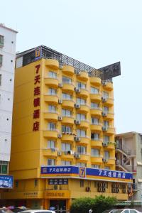 un edificio amarillo con balcones en un lateral en 7Days Premium Beijing Wangjing Nanhu Dongyuan, en Beijing