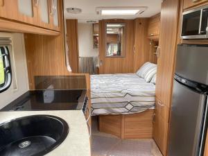 um pequeno quarto com uma cama e uma cozinha em Inviting 4 Berth caravan in Hebden Bridge em Halifax
