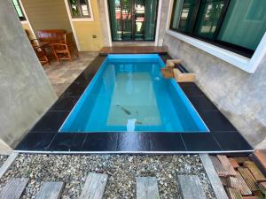 a swimming pool in a house with a tiled floor at Preme House Boutique in San Sai