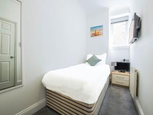 a small bedroom with a bed and a window at OYO Pier Hotel in Clacton-on-Sea