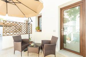 eine Terrasse mit einem Tisch, Stühlen und einem Sonnenschirm in der Unterkunft Sa Domm'e Galleria in Baunei