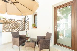 a patio with a table and chairs and an umbrella at Sa Domm'e Galleria in Baunei