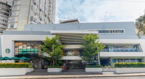 a white building with trees in front of it at Primeway Suites Cebu in Cebu City