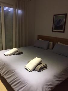 a bedroom with two towels on a white bed at Jardin 10 1071 in El Romero