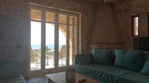 a living room with a couch and a large window at Harmony Seaview Villas In Elafonisos in Elafonisos
