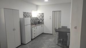 a kitchen with a white refrigerator and a table at Villa Vered in Eilat