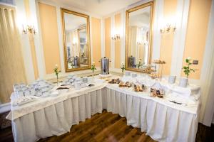 una mesa larga con un mantel blanco y espejos en Spa Hotel Gloria, en Przemyśl