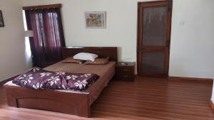 1 dormitorio con 2 camas y suelo de madera en vera home stay en Dehradun