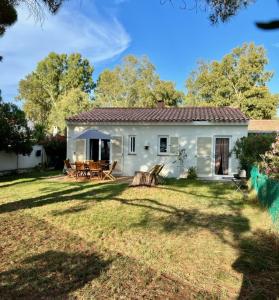 een klein wit huis met een tuin bij maison chaleureuse en plein coeur du centre ville in Saint-Florent