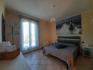 1 dormitorio con cama y ventana grande en Le Giuncaie - Vigna con alloggio, en Montescudaio
