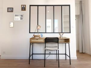 a desk with a chair and a mirror at L'Atelier d'Oscar in Le Havre