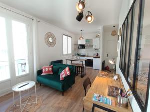 L'Atelier d'Oscar في لو هافر: غرفة معيشة مع أريكة خضراء وطاولة