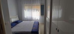 ein Schlafzimmer mit einem Bett mit blauen Kissen und einem Fenster in der Unterkunft Wonderful Sea View Apartment Qerret in Golem