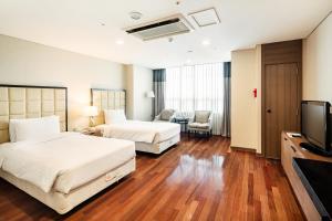 a hotel room with two beds and a flat screen tv at Ramada Hotel and Suites Seoul Namdaemun in Seoul