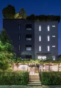 een gebouw met trappen en planten ervoor bij Kitzio House Hotel Huai Kwang in Ban Na Song