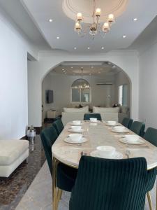 a dining room with a long table and chairs at MK Resort in Doha