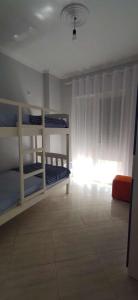 Zimmer mit 3 Etagenbetten und einem Fenster in der Unterkunft Wonderful Sea View Apartment Qerret in Golem
