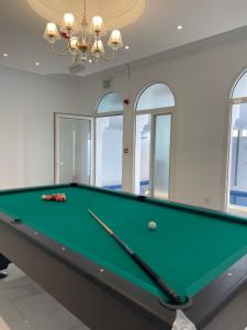 a pool table in a room with windows at MK Resort in Doha