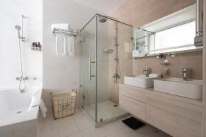 a bathroom with a shower and a sink and a tub at Hotel Inspira-S Tashkent in Tashkent