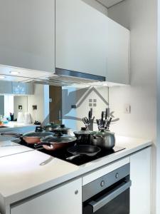 a kitchen with three pots and pans on a stove at Vortex Premium Suites KLCC by SCHIEN in Kuala Lumpur