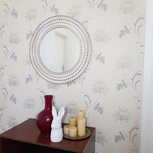 a mirror on a table with candles and a vase at Entsabeni Cottage in Big Bend