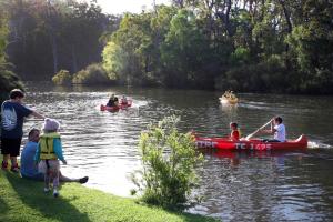 um grupo de pessoas em canoas em um rio em Riverview Tourist Park em Margaret River