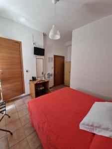 a bedroom with a red bed and a television at Hotel Riz in Finale Ligure