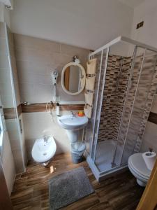 a bathroom with a sink and a toilet and a mirror at Hotel Riz in Finale Ligure