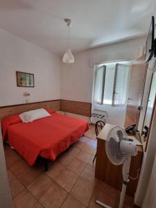 a bedroom with a red bed and a fan at Hotel Riz in Finale Ligure