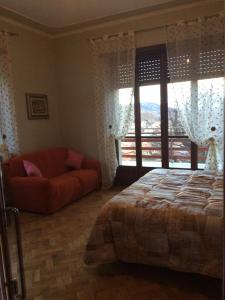 a bedroom with a bed and a couch and a window at Casa Maruca in Gassino Torinese