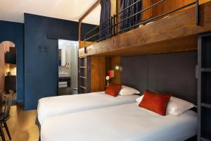 two beds in a room with a bunk bed at Hôtel Marielle in Val Thorens