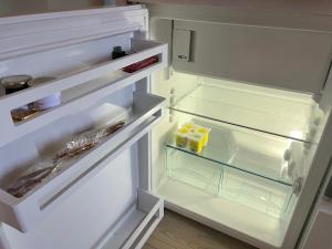 un réfrigérateur ouvert, porte ouverte, avec des bouteilles jaunes à l'intérieur dans l'établissement Au cœur du vieux Toulon au calme appartement rénové climatisé confortable étage élevé avec ascenseur proche parking et toutes commodités, à Toulon 28 autres photos