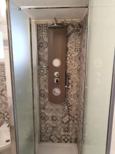 La salle de bains est pourvue d'une douche et d'une porte en verre. dans l'établissement Stella Maris, à Conversano