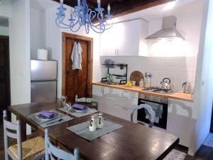 a kitchen with a wooden table and a refrigerator at Charming cottage in the heart of the Ribera sacra in Castro Caldelas