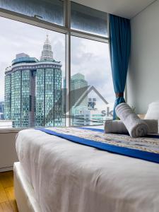 a bedroom with a large window with a view of a city at Vortex Premium Suites KLCC by SCHIEN in Kuala Lumpur