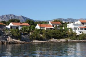 a group of houses on the shore of the water at Rooms by the sea Sucuraj, Hvar - 6734 in Sućuraj