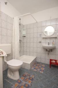 a white bathroom with a toilet and a sink at Rooms by the sea Sucuraj, Hvar - 6734 in Sućuraj