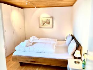 a small bedroom with a bed with white sheets at Mountain View in Andermatt