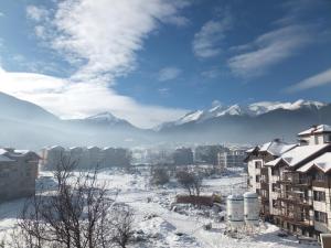een besneeuwde stad met bergen op de achtergrond bij Bansko Prespa Ski Penthouse in Bansko