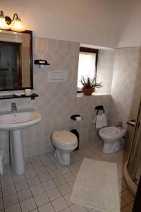 bagno con lavandino, servizi igienici e specchio di Apartment Piazza Matteotti a Greve in Chianti