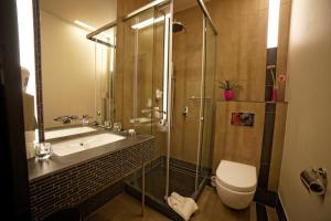 a bathroom with a shower and a toilet and a sink at Hotel Martina in Żnin