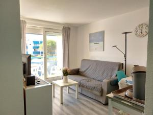 sala de estar con sofá y mesa en Appartement T 2 AVEC PISCINE, en Lacanau