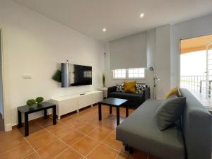 sala de estar con sofá y TV de pantalla plana en El Mirador del Coto, en Sanlúcar de Barrameda
