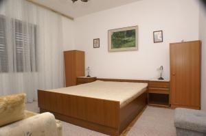 um quarto com uma cama, um armário e uma cadeira em Apartments by the sea Podaca, Makarska - 2576 em Podaca
