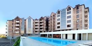 ein Apartmentkomplex mit einem Pool vor den Gebäuden in der Unterkunft Panorama Resort&Suites in Yerevan